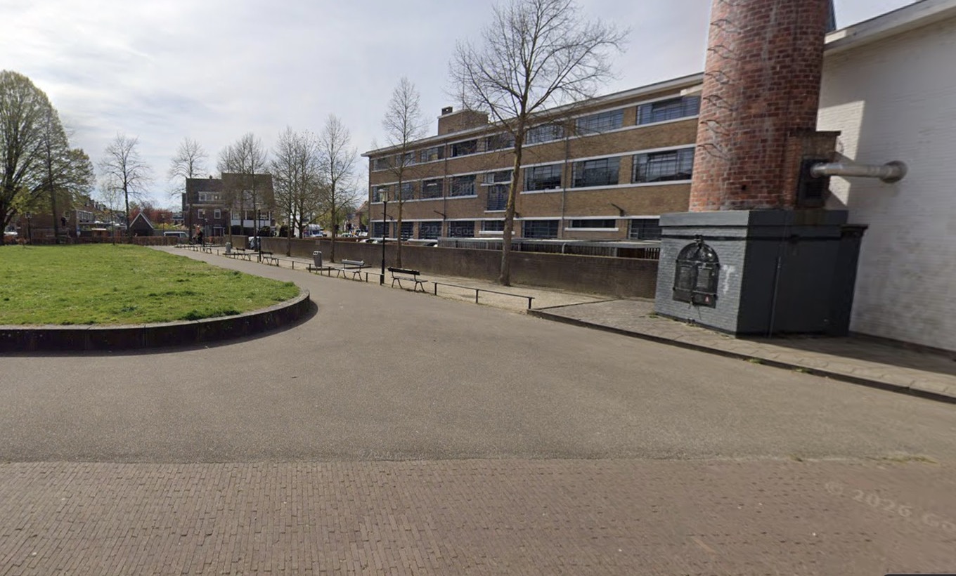 De jeu-de-boulesbanen op het Laboratoriumplein: een grindstrook met bankjes tussen het grasveld en de oude fabrieksschoorsteen